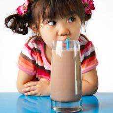 девочка, пьющая какао из стакана через трубочку