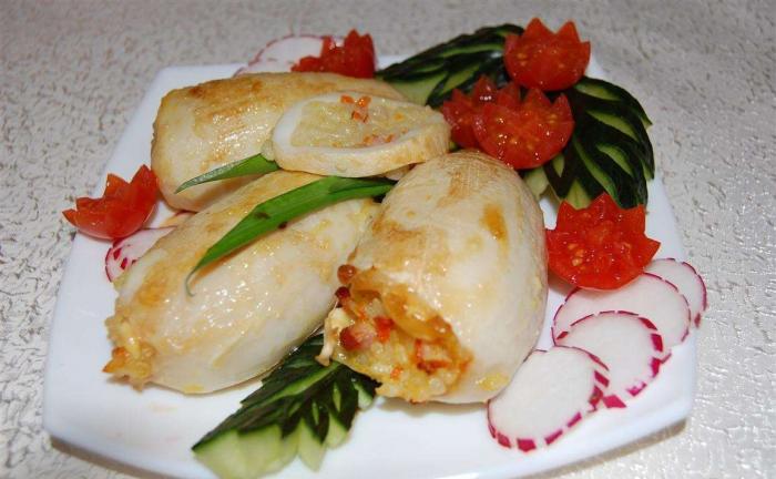 фаршированные тушки кальмаров на тарелке с овощами