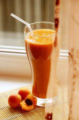 густой абрикосовый сок в стакане с трубочкой