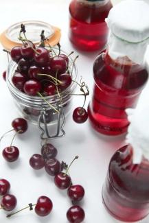 свежие вишни и сок в бутылках