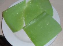 ломтики зеленого сыра песто на тарелке
